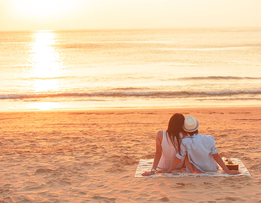 A couple enjoying a sunset on the beach